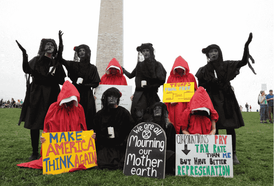 Rebels draped in black joined forces with a group dressed as women from The Handmaid's Tale